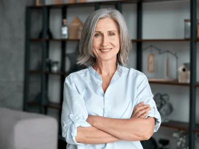 A confident woman standing with her arms folded in a home study