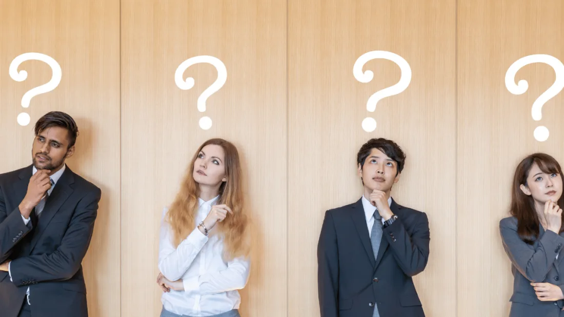 Four professionals in business attire looking upward, each with a question mark above their head