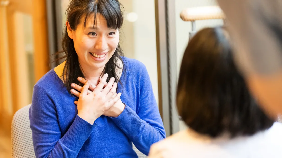 A counsellor and client in conversation, the client smiling warmly with her hands over her heart