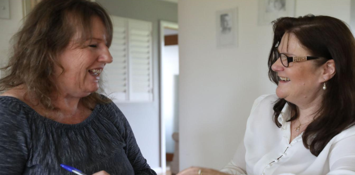 Carrie Wallis working one to one with a client at her desk